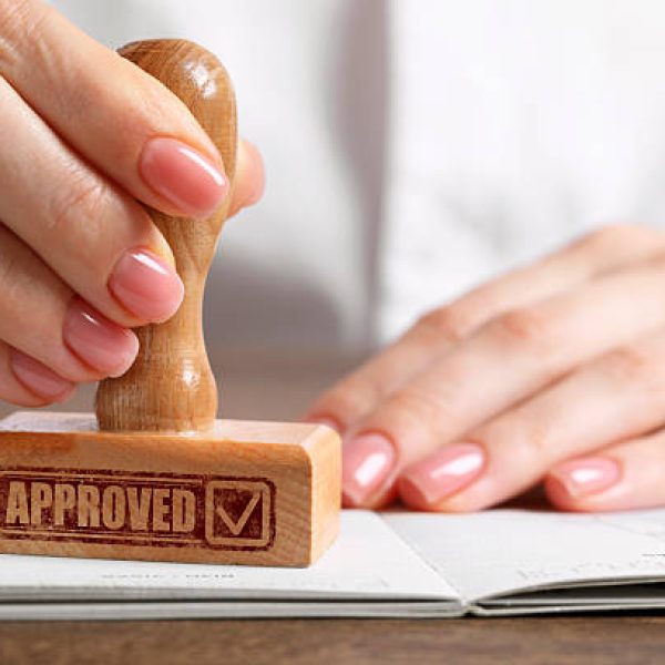 approved. woman stamping passport at table, closeup